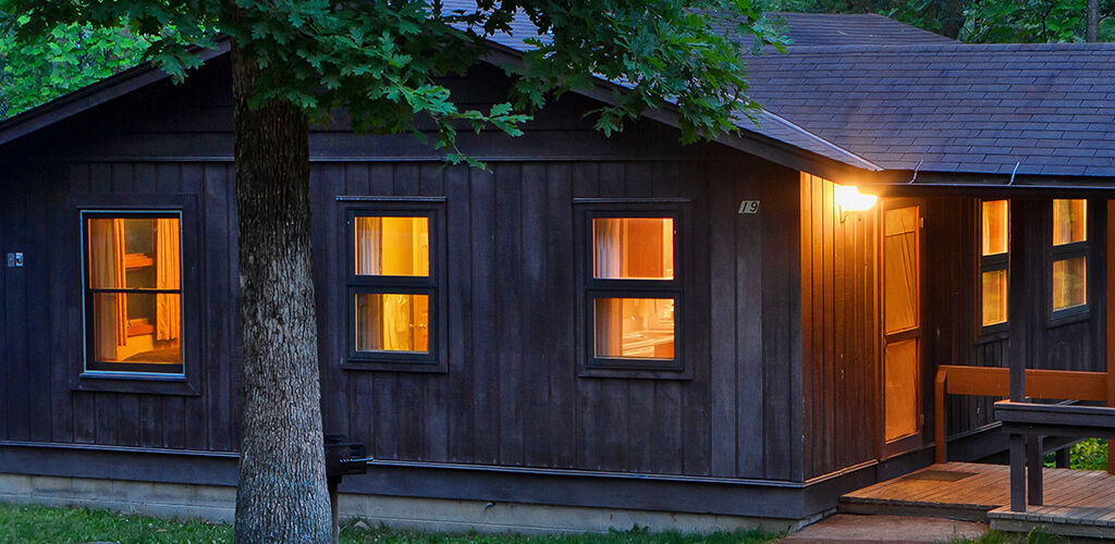 Cabin with the lights on at dusk