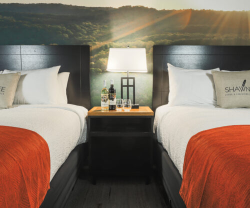 View of two queen beds neatly made at Shawnne State Park Lodge